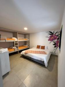 um quarto com uma cama com uma flor pintada na parede em La posada de Rubi em Salento