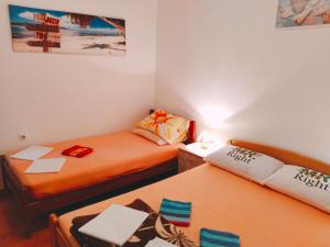two beds in a small room with orange sheets at Apartments Sonja in Kotor