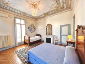 Résidence La Villa Léonie في نيس: غرفة نوم بسرير ومدفأة