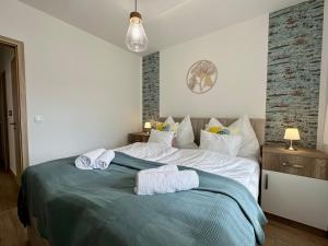 a bedroom with a bed with towels on it at Sunshine Resort Blue Apartman in Zamárdi