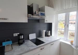 a kitchen with white cabinets and a counter top at Elegante Einzimmerwohnung in Flensburg