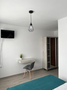 a bedroom with a black chair and a table at Piscul Muntelui in Moieciu de Sus