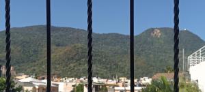 a view of a city from a window with mountains at Alojamiento Acogedor in San Felipe de Puerto Plata