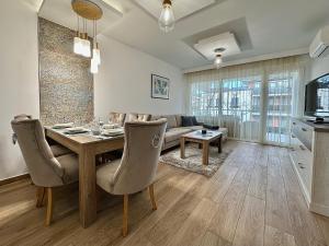佐馬爾迪的住宿－Sunshine Resort Blue Apartman，客厅配有桌子和沙发