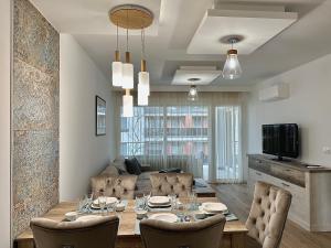 uma sala de jantar e sala de estar com mesa e cadeiras em Sunshine Resort Blue Apartman em Zamárdi