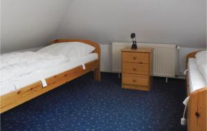 ドルム・ノイフェルトにあるAwesome Home In Wurster Nordseekste With 3 Bedrooms And Wifiのベッドルーム1室(ベッド2台、ナイトスタンド付)