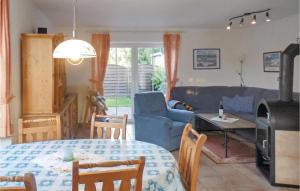 ドルム・ノイフェルトにあるAwesome Home In Wurster Nordseekste With 3 Bedrooms And Wifiのリビングルーム(青いソファ、テーブル付)