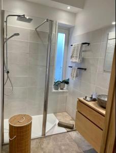 une salle de bain avec une douche, une baignoire et un lavabo dans l'établissement Chaleureux appartement entre lac et montagne, à Neuvecelle