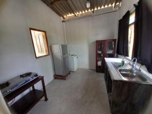a kitchen with a sink and a refrigerator in a room at Asanka Beach Stay in Mirissa