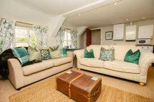 een woonkamer met twee banken en een koffer bij Carters Cottage - Rudge Farm Cottages in Bridport