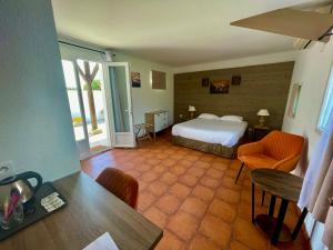 une chambre d'hôtel avec un lit, une table et des chaises dans l'établissement Mas Des Salicornes, à Saintes-Maries-de-la-Mer
