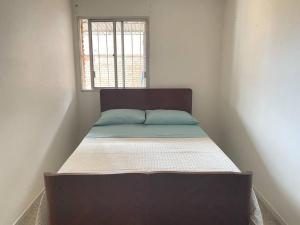a bed in a small room with a window at Departamento vivienda completo in Carmelo