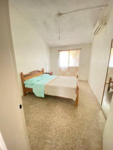 een slaapkamer met een bed en een raam bij Departamento vivienda completo in Carmelo