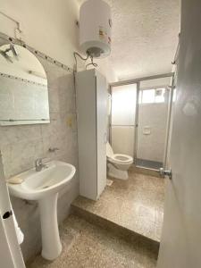 een badkamer met een wastafel en een toilet bij Departamento vivienda completo in Carmelo