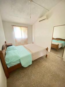 een slaapkamer met een bed en een spiegel bij Departamento vivienda completo in Carmelo