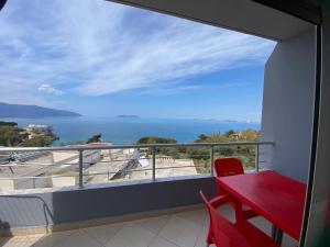 czerwony stół i krzesła na balkonie z widokiem na ocean w obiekcie Sea View Apartment we Wlorze