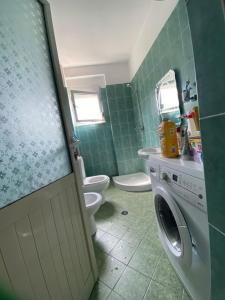 łazienka z toaletą i pralką w obiekcie Sea View Apartment we Wlorze