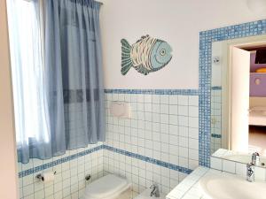 a bathroom with a toilet and a fish on the wall at Appartamento Castel Sant'Angelo in Licata
