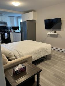 a bedroom with a bed and a table and a tv at Brand new, One bedroom, two bed separated suite. in Victoria