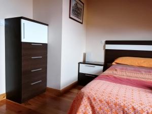 een slaapkamer met een bed en een dressoir bij Duplex Colombres in Colombres