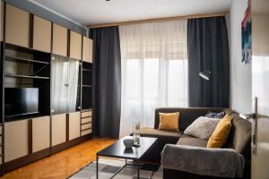 een woonkamer met een bank en een tafel bij Apartment SOUL in Knin