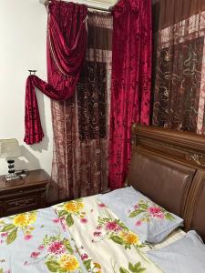 a bed in a bedroom with red curtains at GHIZLAN apartment TETOUAN in Tétouan
