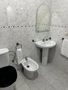 a bathroom with a sink and a toilet and a mirror at GHIZLAN apartment TETOUAN in Tétouan