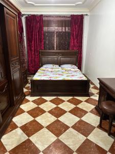 a bedroom with a bed and a checkered floor at GHIZLAN apartment TETOUAN in Tétouan