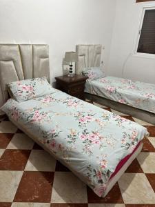 a bedroom with two beds and a table at GHIZLAN apartment TETOUAN in Tétouan