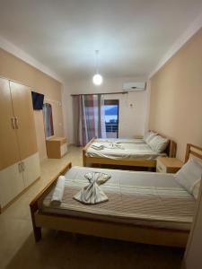 Un dormitorio con 2 camas y una mesa con una toalla. en Hotel Odeon 3 en Vlorë