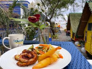 un plato de comida en una mesa con una taza de café en Beachfront Glamping with Mini Pool Exclusive Property, en Lingayen