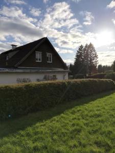 ein Haus mit einer Hecke vor einem Haus in der Unterkunft Ferienwohnung Isis in Neufang in Sonneberg