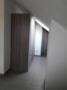 pasillo vacío con puerta de madera y suelo de baldosa en Fewo Steinhohle, DG 45qm, 1 Schlafzimmer & 1 Wohn-Esszimmer mit Bett, en Sulzbach am Main