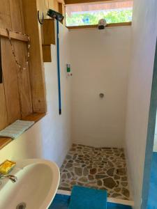 a bathroom with a sink and a shower with a window at Cabañas Casa Soley in Puerto Soley