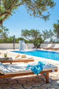 a pool with tables and chairs next to a swimming pool at Fantasy Rooms in Adamantas