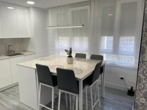 uma cozinha branca com mesa e cadeiras em Maitika em Santander