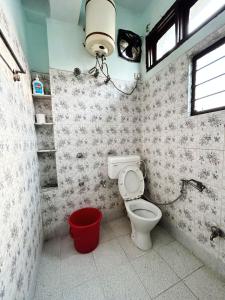łazienka z toaletą, lampką i wiadrem w obiekcie Garden Central - 2 Bedroom Apartment, Siliguri w mieście Siliguri