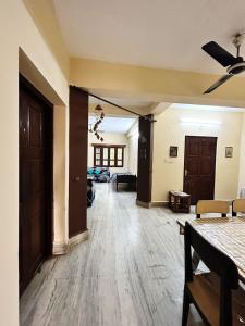 salon z drewnianą podłogą i korytarzem w obiekcie Garden Central - 2 Bedroom Apartment, Siliguri w mieście Siliguri