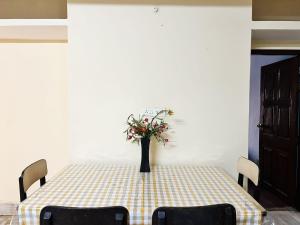 stół z wazonem z kwiatami w obiekcie Garden Central - 2 Bedroom Apartment, Siliguri w mieście Siliguri