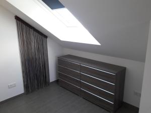 a room with a wooden dresser and a skylight at Fewo Steinhohle, DG 45qm, 1 Schlafzimmer & 1 Wohn-Esszimmer mit Bett in Sulzbach am Main
