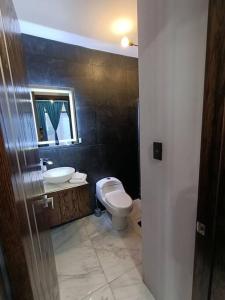 y baño con aseo, lavabo y espejo. en moderno apartamento en el centro de la ciudad, en Chihuahua