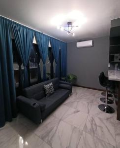 sala de estar con sofá y cortinas azules en moderno apartamento en el centro de la ciudad en Chihuahua