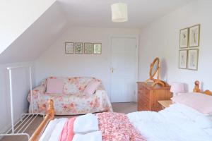 um quarto com uma cama, uma cadeira e uma cómoda em Spacious North Devon villa with beautiful garden em Bideford