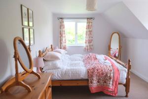 a bedroom with a bed with a mirror and a window at Spacious North Devon villa with beautiful garden in Bideford