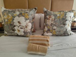 Una cama con dos almohadas y una toalla. en Classy and cosy Apt - Dainfern, en Fourways