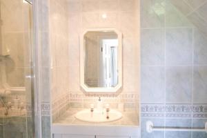 uma casa de banho com um lavatório, um espelho e um chuveiro em Spacious North Devon villa with beautiful garden em Bideford