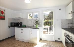 een witte keuken met een wastafel en een aanrecht bij Beautiful Apartment In Gemenos With Outdoor Swimming Pool in Gémenos