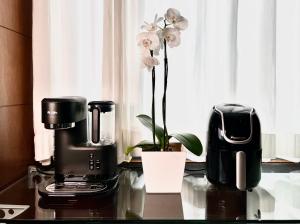 a table with a coffee maker and a flower on it at Flat em região nobre in Belo Horizonte