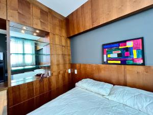 um quarto com uma cama e um quadro na parede em Flat em região nobre em Belo Horizonte
