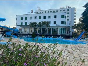 a hotel with a pool and a slide at Hotel Brasil in São Lourenço